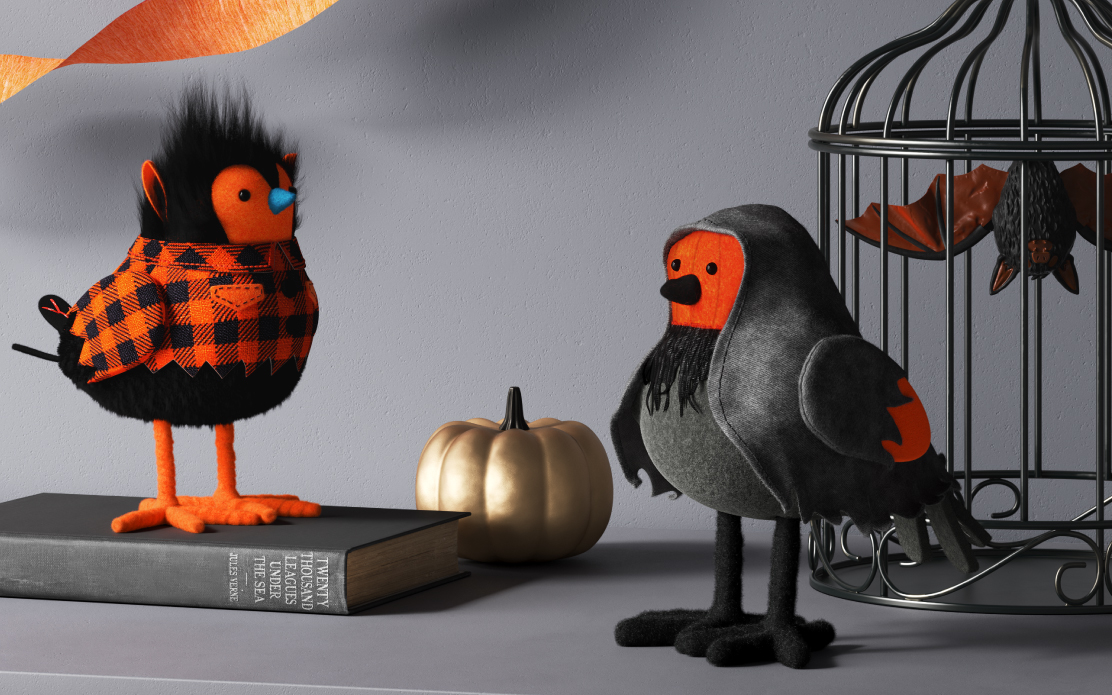 A Featherly Friends bird stands on a book next to another bird in front of a black iron cage.