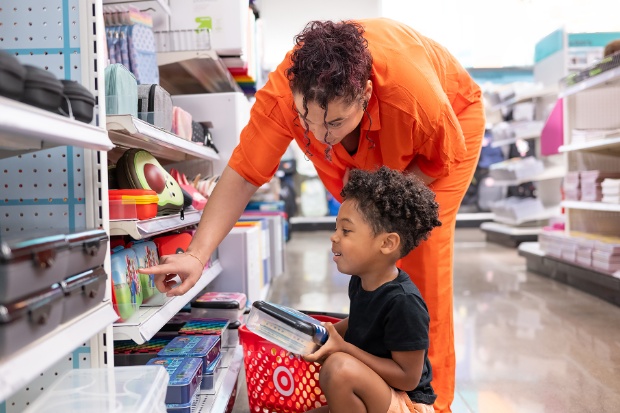 A parent points out a back-to-school product to their excited child.