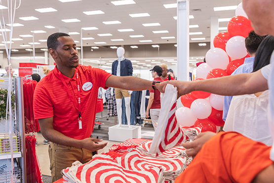 A team member hands a guest a bag;