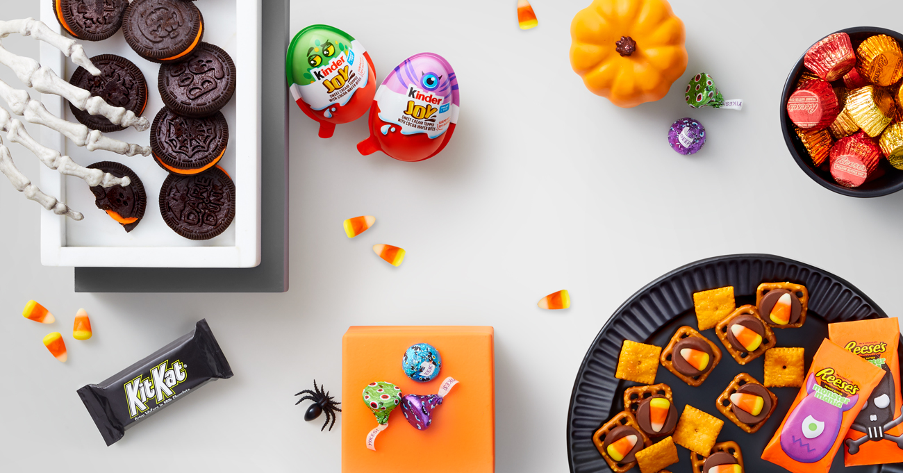 A skeleton hand reaches for an Oreo, surrounded by more Halloween treats