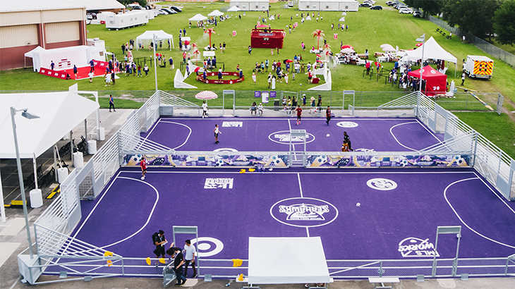 Neptune Middle School's two new purple soccer pitches with community day festivities taking place on a green field behind them