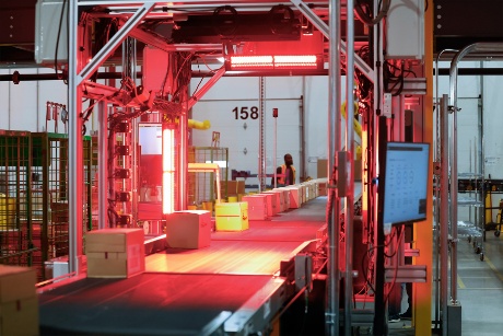 Boxes on a conveyor belt move under a label scanner.