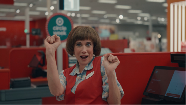 Actress Kristen Wiig as her “Target Lady” character stands behind a Target checkout counter.