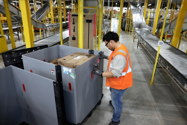 A team member wearing a vest assembles a pod to hold orders.