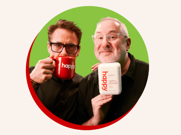 Robert Downey Jr. Holding a red coffee mug that says ‘happy’ and Craig Dubitsky holding a white container of happy coffee.