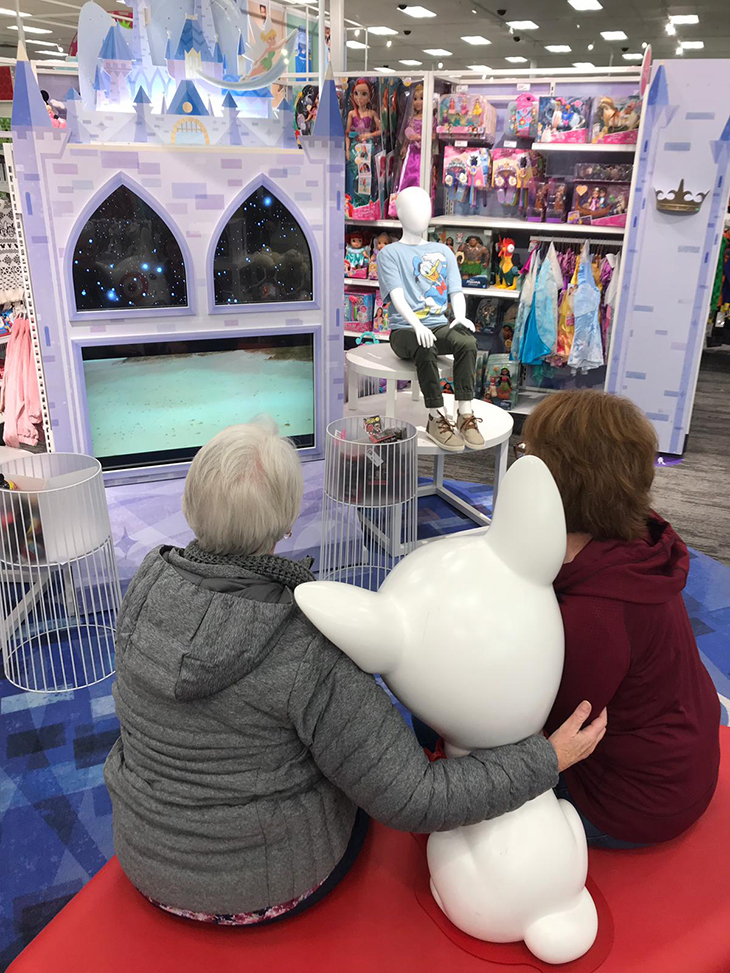 Two guests take a photo together in the Disney Store area