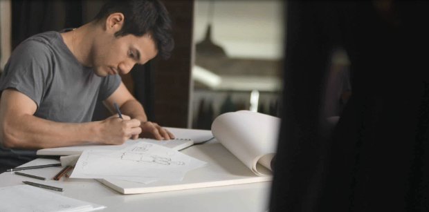 a man writing on a piece of paper