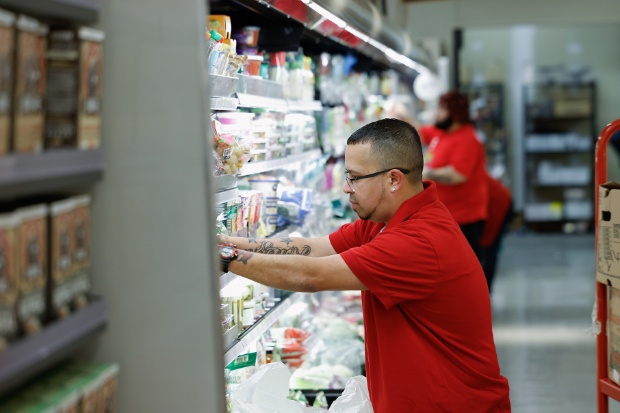 Three team members stock an open cooler with food.