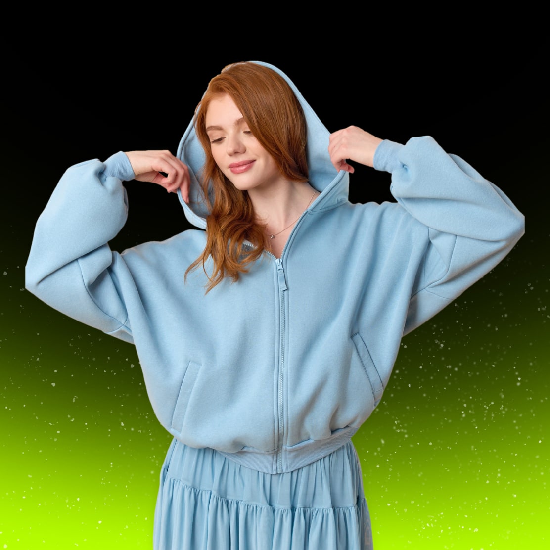 A person wearing a Blogilates light blue zip-up hoodie with the hood up, paired with a matching blue skirt.