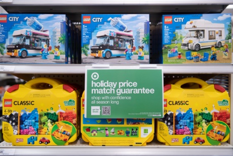 A Holiday Price Match Guarantee sign hovers over a LEGO display.