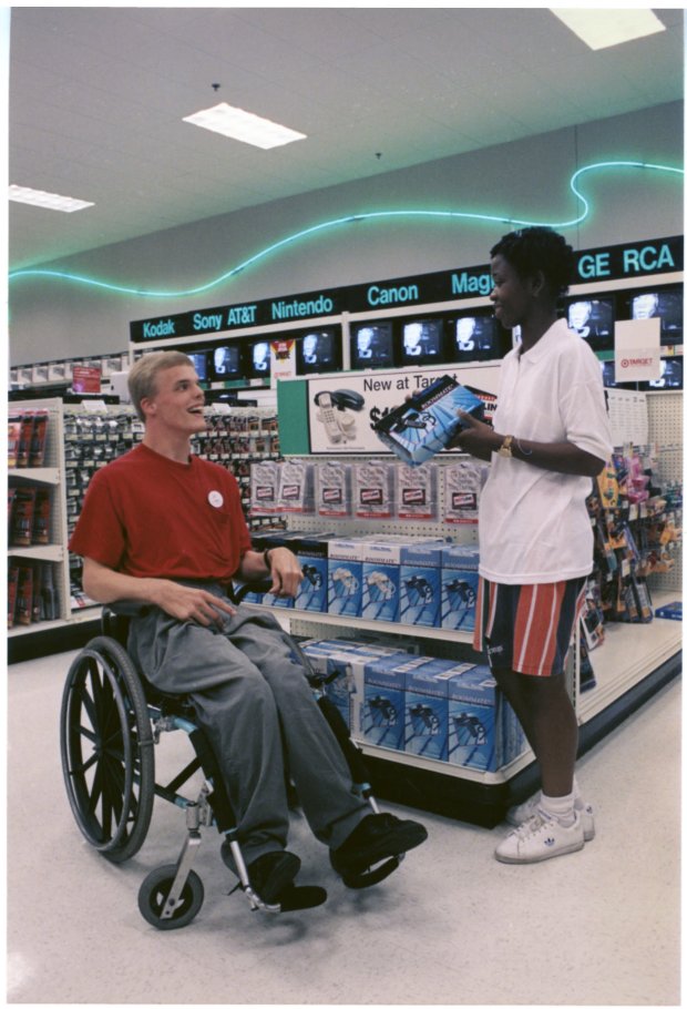 a woman in a wheelchair talking to a man in a wheelchair