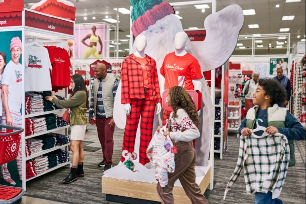 Holiday pajama section with mannequins dressed in plaid and shoppers browsing apparel.