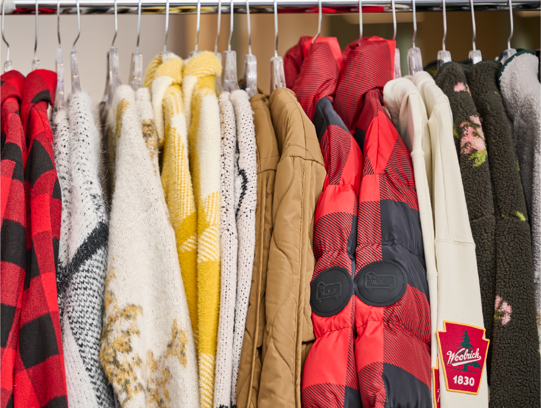 A row of Woolrich x Target clothes hanging on a rack.