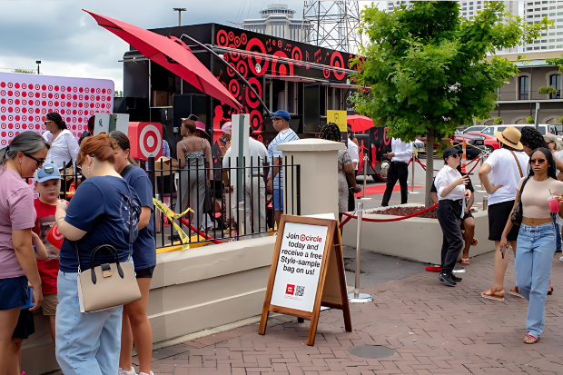 A crowd is gathered outdoors around a truck displayed Bullseye logos. 