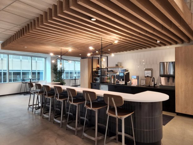 a large kitchen with a bar and chairs