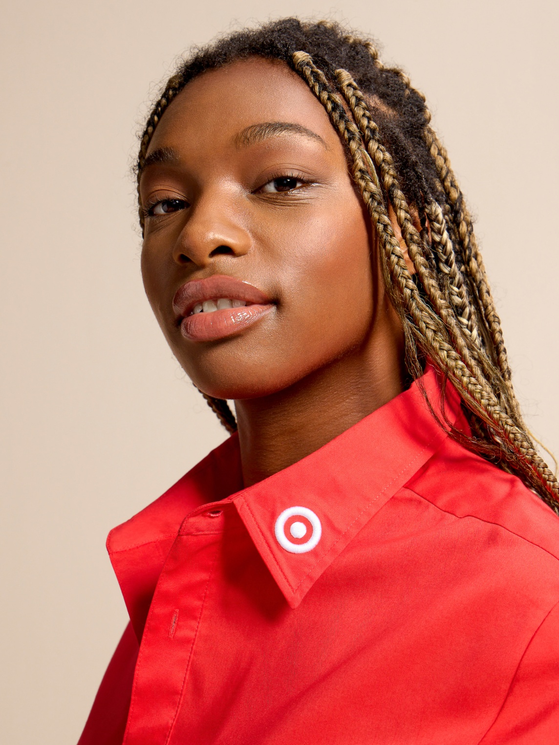 Close-up studio portrait highlighting a red Target-branded shirt with a bullseye logo detail on the collar
