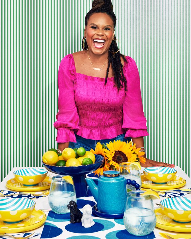 a woman sitting at a table with food and drinks