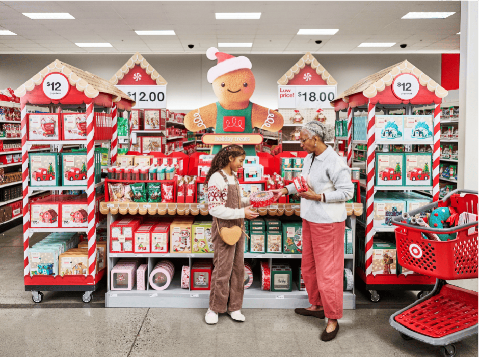 A child and adult stand in front of a selection of holiday cookies at a Target store.