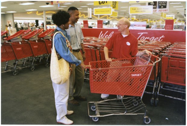 a few people standing next to a shopping cart