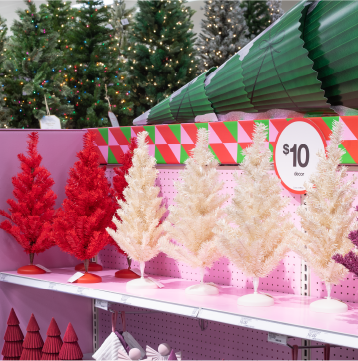A shelf with tiny red and white Christmas trees.