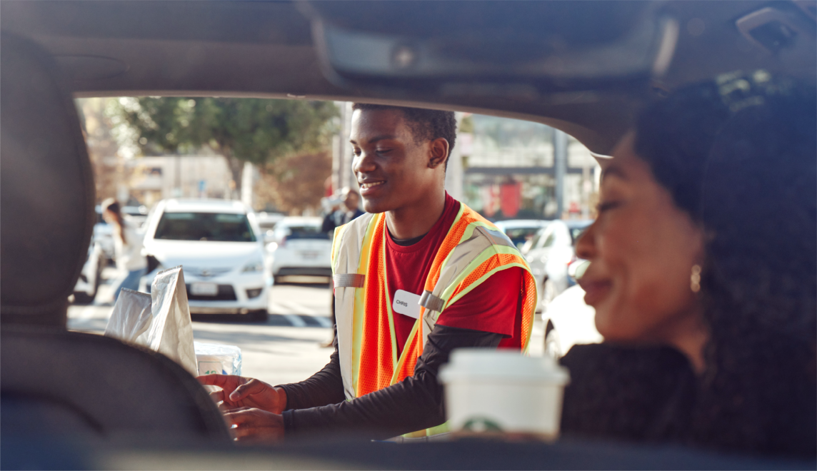 A Target Drive Up team member delivers packages to the back of a guest’s car.