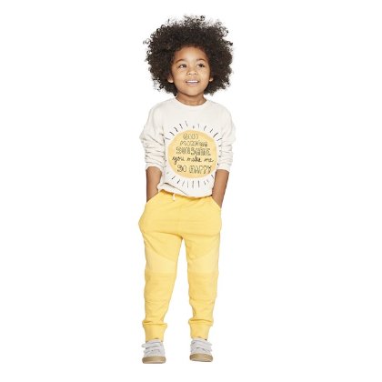 a young boy wearing a white shirt and yellow pants