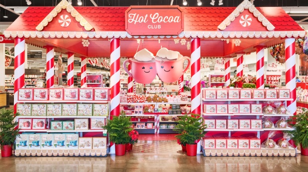 Front view of Hot Cocoa Club display with candy cane pillars and shelves of cocoa kits.