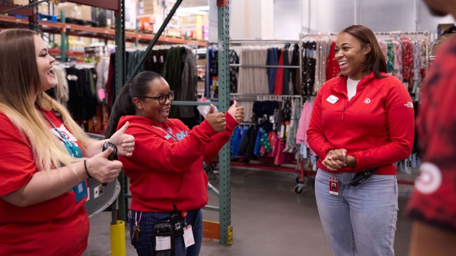 A group of Target team members giving each other a thumbs up as they huddle in the back of the store.