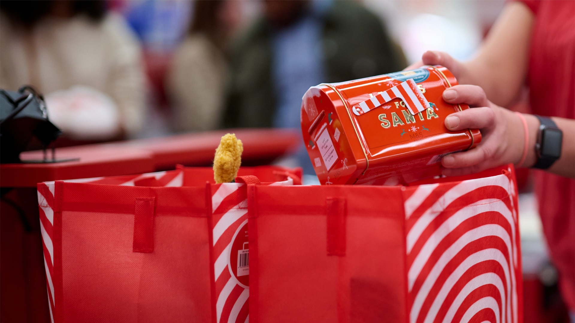 A team member places a novelty Santa’s mailbox into a Target reusable bag.