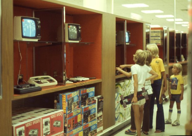 a group of kids stand in front of a television