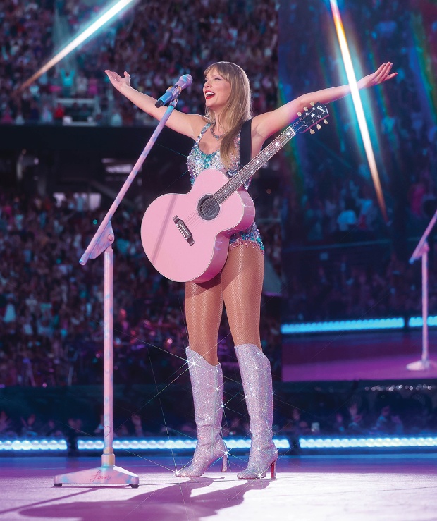 Taylor Swift on stage using the “Lover” era pink guitar