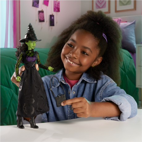 A child plays with an Elphaba doll.